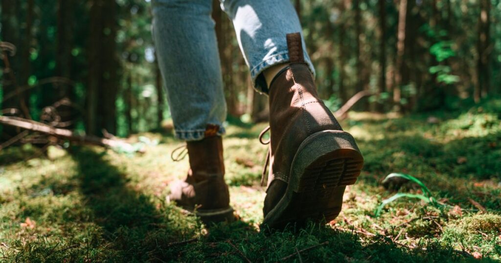 person walking through the woods during tick season in Raleigh, NC